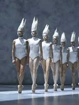 na zdjęciu po lewej stronie chłopiec patrzący przez duże okno, przed oknem rząd baletnic w białych strojach typu body i białych nakryciach głowy