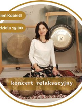 Kobieta siedzi przy misach i gongach do grania.