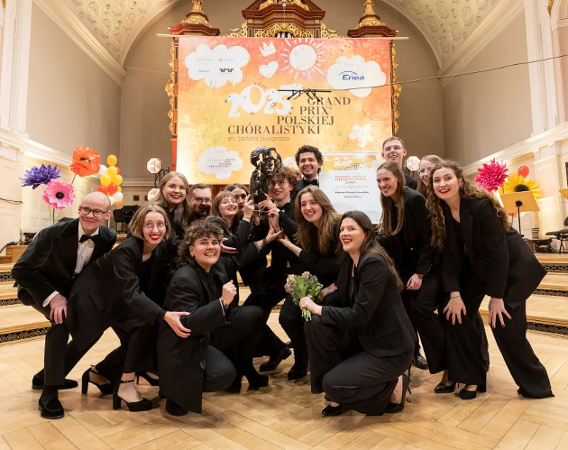 Grupa chórzystów cieszy się ze zdobytej nagrody.
