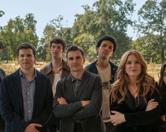 Grupa mężczyzn i kobiet stoi na tle drzew.