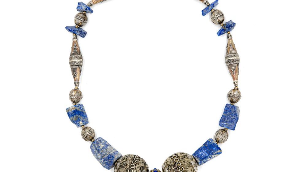 Kamienna bransoleta składająca się z różnych elementów i ozdobnych koralików w różnych kształtach, dominuje kolor niebieski, a'la lapis lazuli.