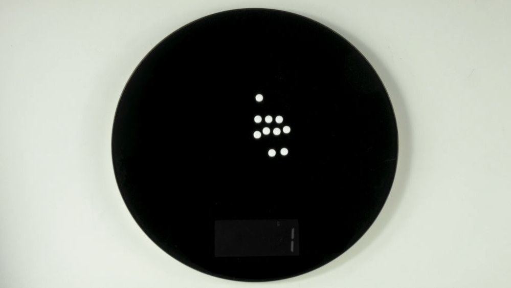Czarno-biały abstrakcyjny obraz przedstawiający duże czarne koło z białymi kropkami w środku.