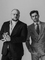 Panowie stykają się ramionami.