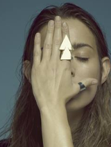 na zdjęciu kobieta zakrywa twarz dłonią