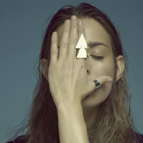 na zdjęciu kobieta zakrywa twarz dłonią