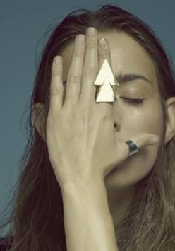 na zdjęciu kobieta zakrywa twarz dłonią