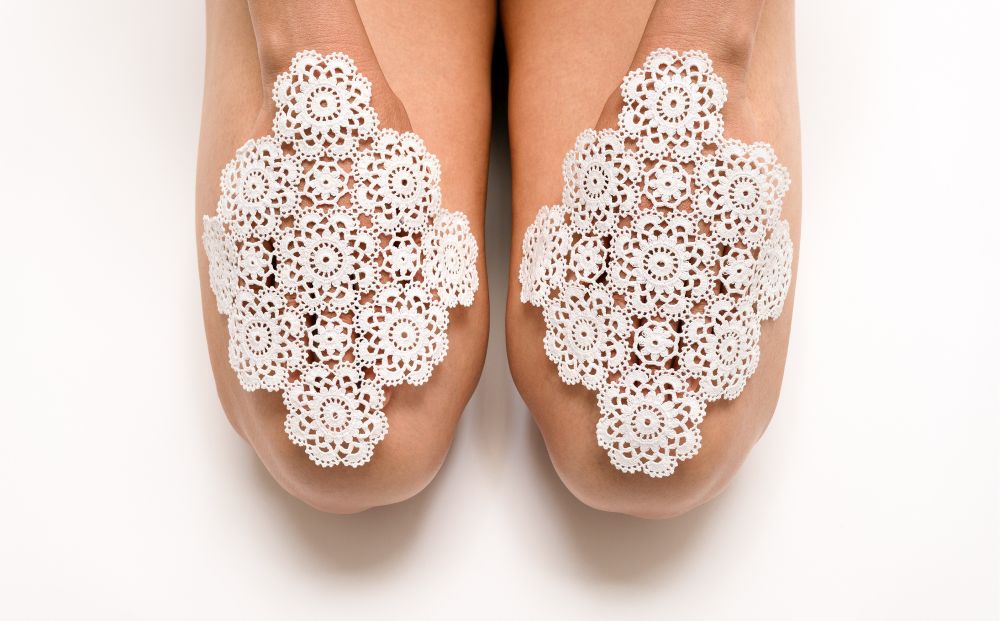 Kobiece dłonie oparte na udach, przykryte białymi serwetkami.