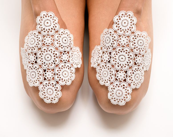 Kobiece dłonie oparte na udach, przykryte białymi serwetkami.