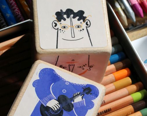 Kolorowe klocki leżą na kolorowych kredkach.