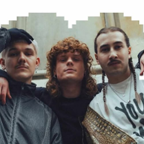 Troje artystów w pozie hip-hopowej.