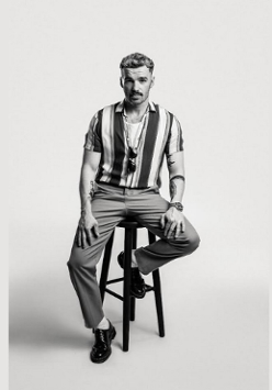 Mężczyzna siedzi na krześle na czarno-białym zdjęciu.