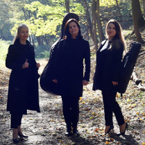 Trzy kobiety stoją na leśnej ścieżce.