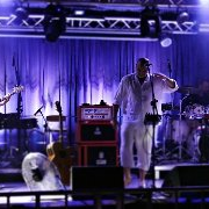 Zdjęcie przedstawia czterech muzyków rockowych występujących na scenie.