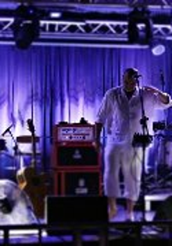 Zdjęcie przedstawia czterech muzyków rockowych występujących na scenie.