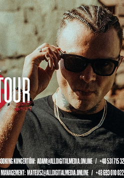 Mężczyzna w ciemnych okularach chwyta się za ich oprawkę, obok napisy informujące o szczegółach wydarzenia, za nim ceglana ściana.