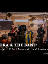 Kobieta na scenie w restauracji z zespołem.