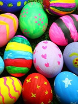 Kolorowe pisanki leżą na trawie.