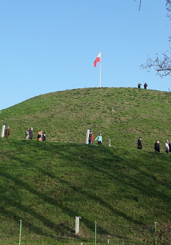 Kopiec Wolności w Poznaniu, po którym spacerują mieszkańcy.