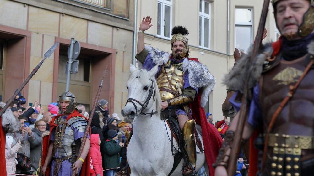 Korowów przechodzi ulicą Święty Marcin, na zdjęciu widać samego Świętego Marcina w złotym stoju legionisty i na białym koniu, machającego do tłumu.