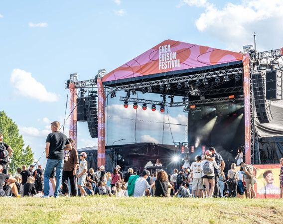 Letni festiwal, widoczna scena, ludzie bawiący się na trawie