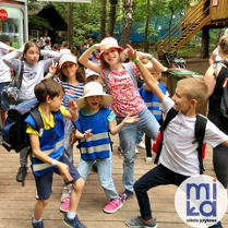 zdjecie rozesmianych dzieci na drewnianym placu zabaw