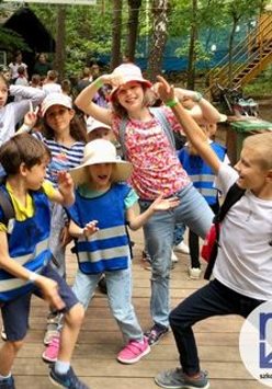 zdjecie rozesmianych dzieci na drewnianym placu zabaw