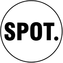 Obrazek to logo fundacji spot. Składa się ono z napisu spot wykonanego prostymi, wielkimi literami z kropką po ostatniej literze. Napis jest wpisany w okrąg, a całe logo utrzymane jest w czerni i bieli.
