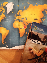 Uproszczona mapa świata, a w jej narożnku leży książka.