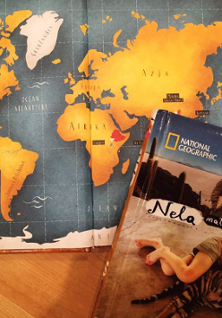 Uproszczona mapa świata, a w jej narożnku leży książka.