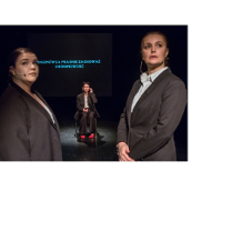 Na czarnym tle widoczna jest postać kobiety siedzącej na krześle, ubranej w białą bluzkę, brązową marynarkę i brązowe spodnie. Z przodu, przed nią, stoją naprzeciwko siebie dwie kobiety ubrane tak samo. Patrzą w obiektyw.