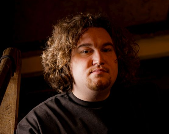 Mężczyzna w dłuższych, kręconych włosach.