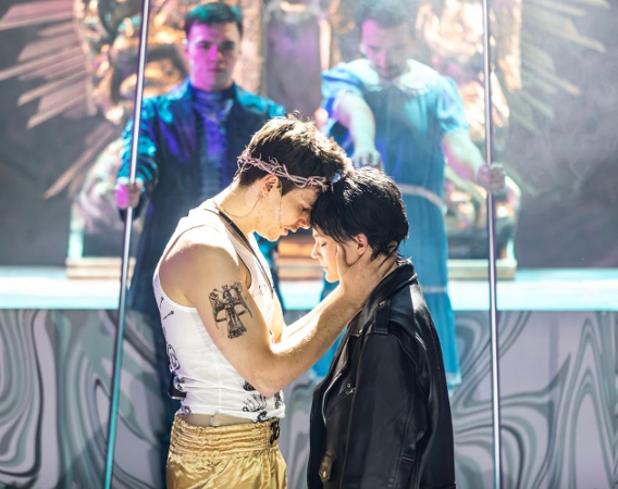 Mężczyzna w koronie cierniowej na głowie przytula dziewczynę w skórzanej kurtce.