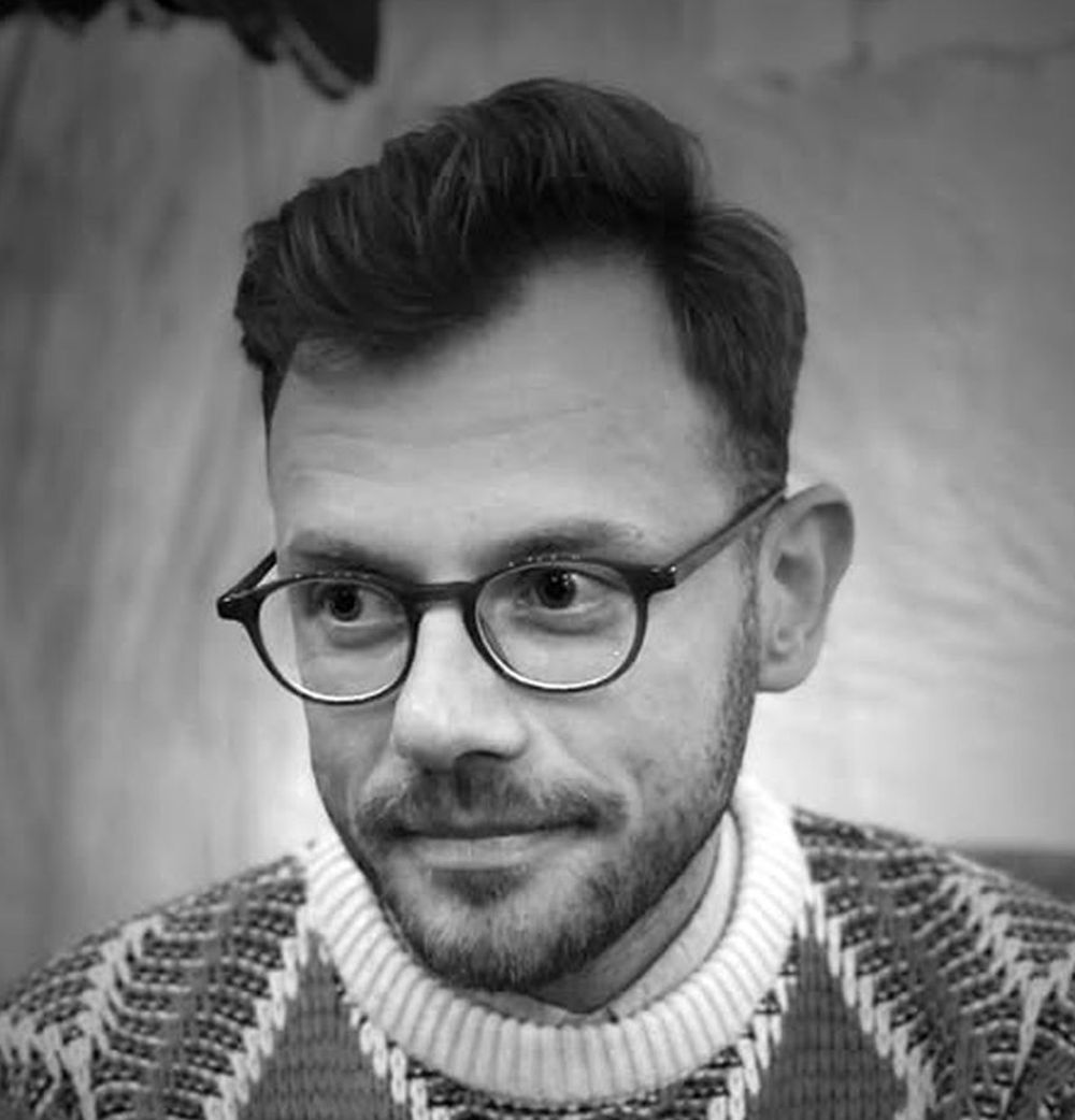Dariusz Zych, fot. Fot. Marcin Muth/Galeria w Bramie Mężczyzna w średnim wieku, z pogodnym wyrazem twarzy, w okularach.