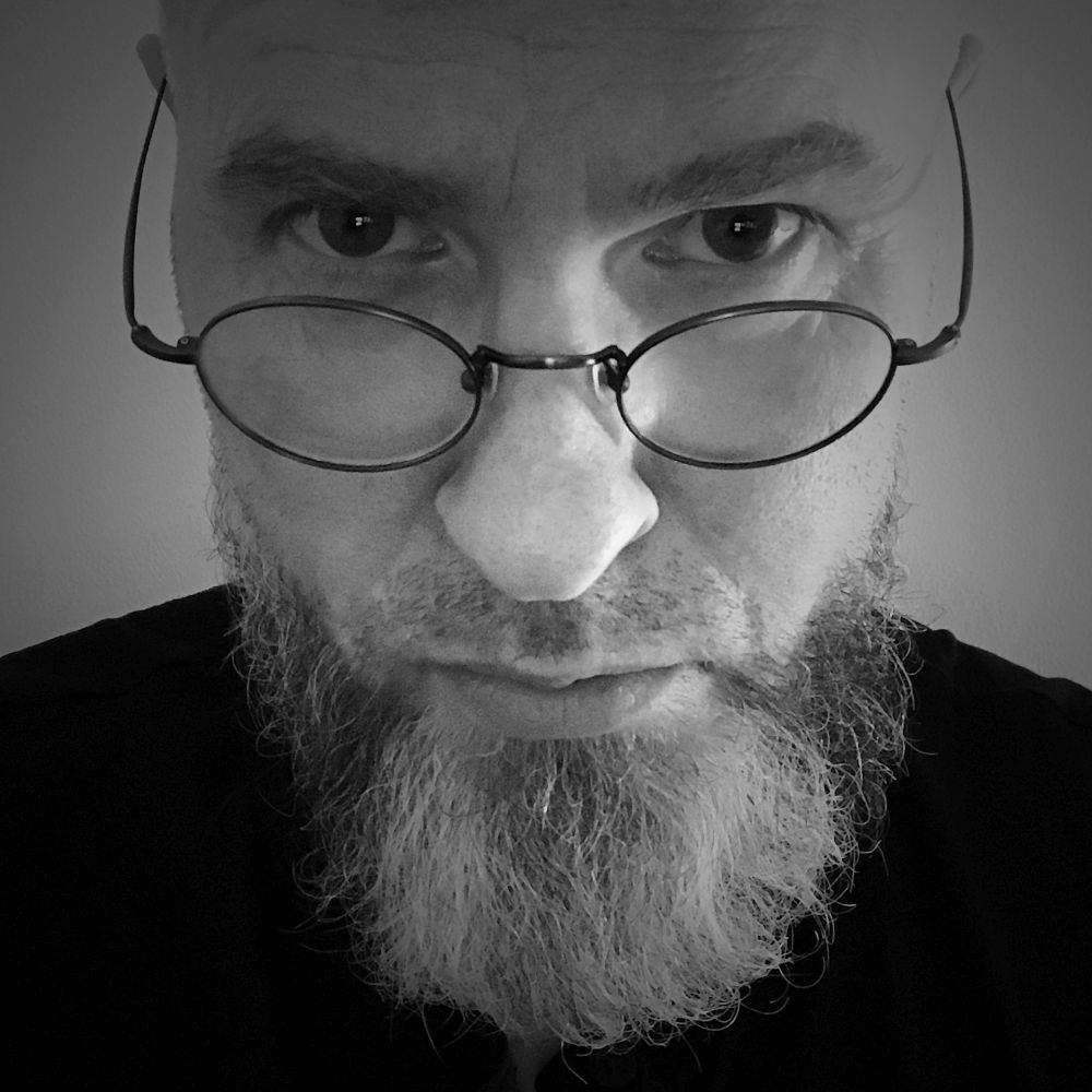 Marcin Muth, fot. autoportret, archiwum prywatne Mężczyzna z brodą i w okularach.