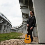 Michał Obrębski z gitarą pod wiaduktem.