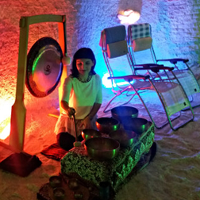 Grota solna, kobieta gra na misach i gongach, leżaki dla uczestników.