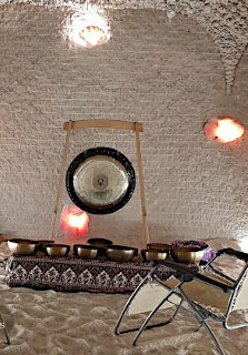 Ceglana ściana, na dywanie misy, przy ścianie gong, w pobliżu leżaki.