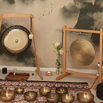 Sala, w której roztawione są misy i gongi na wzorzystym dywanie.