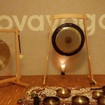 Zdjęcie przedstawia misy i gongi stojące pod ścianą, na której jest napisana nazwa miejsca koncertu na owe instrumenty, czyli Lovayoga.