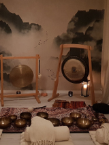 Pomieszczenie z dywanami i gongami. Na dywanach leżą misy. W tle tapeta z chmurami i ptakami. Po prawej stronie zasłona, przez którą przebija światło.