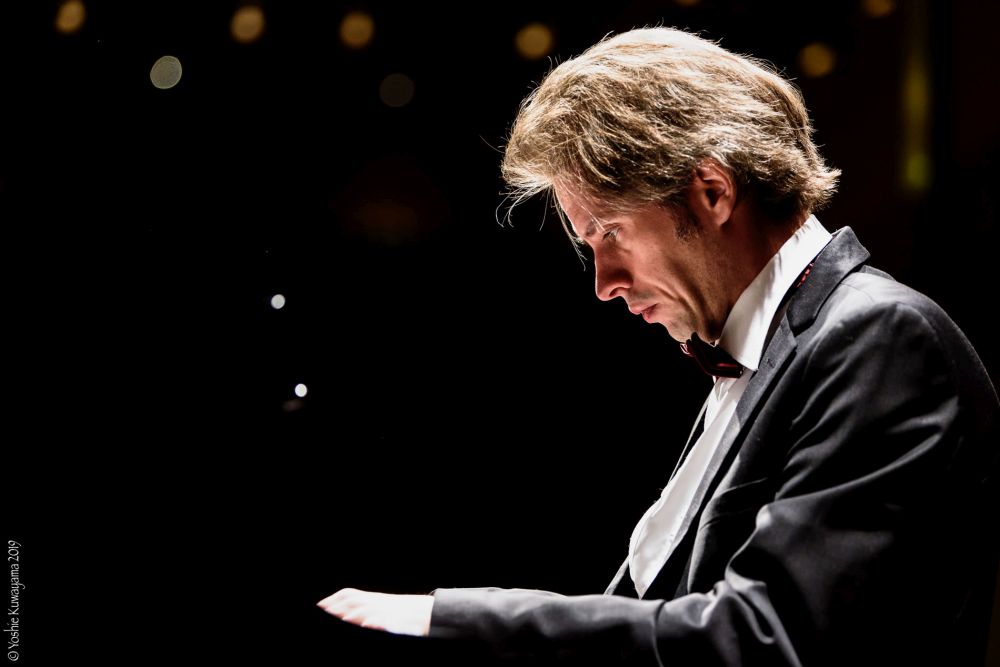 Młody mężczyzna gra na fortepianie.