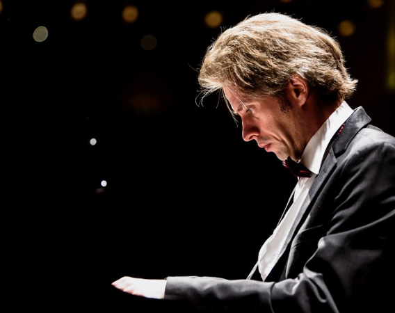 Młody mężczyzna gra na fortepianie.