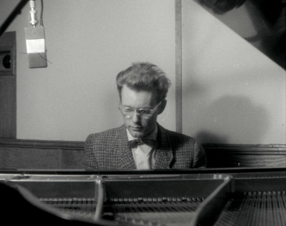 Młody mężczyzna gra na fortepianie.