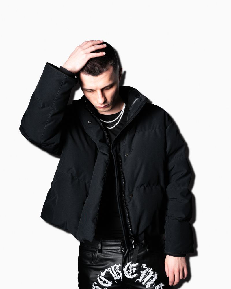 Młody mężczyzna w czarnej kurtce.