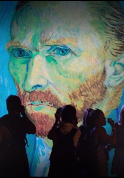 Grupa wycieczkowa robi zdjęcie portretu Van Gogha.