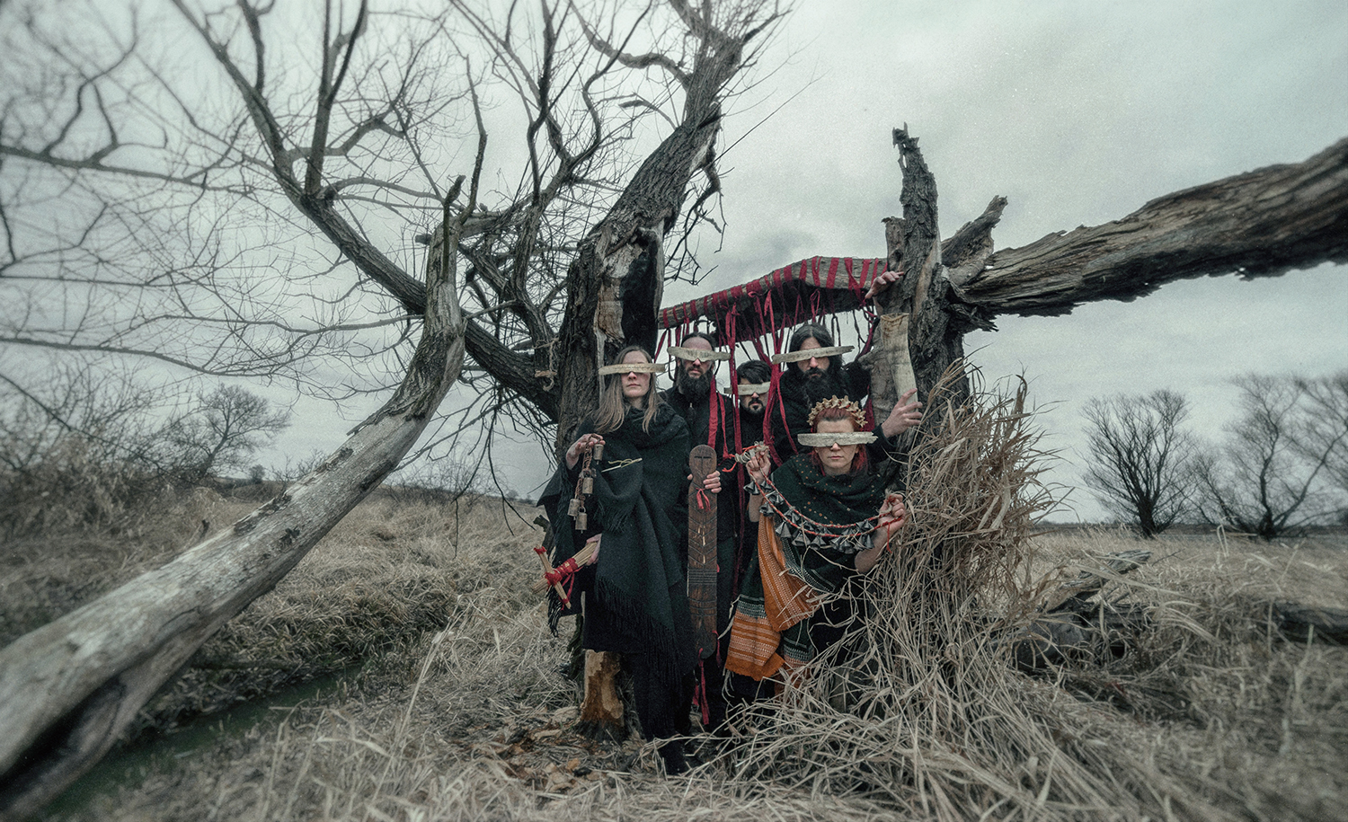 Muzycy w ludowych strojach z deseczkami zasłaniającymi oczy