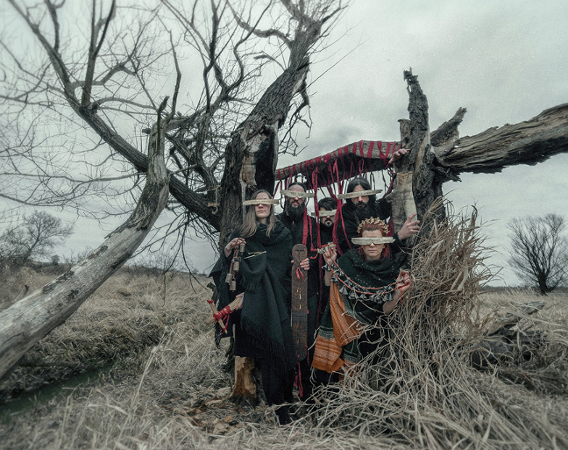 Muzycy w ludowych strojach z deseczkami zasłaniającymi oczy