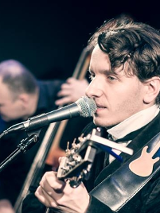 na zdjęciu Przemek Mazurek gra na gitarze