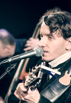 na zdjęciu Przemek Mazurek gra na gitarze