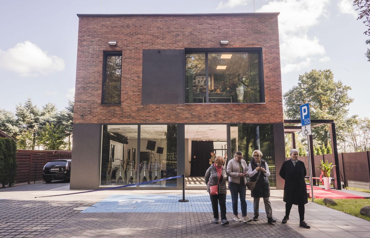 DK AZK, miejski dom kultury, fot. Grzegorz Dembiński Nowoczesny budynek jednopiętrowy, przed nim ludzie